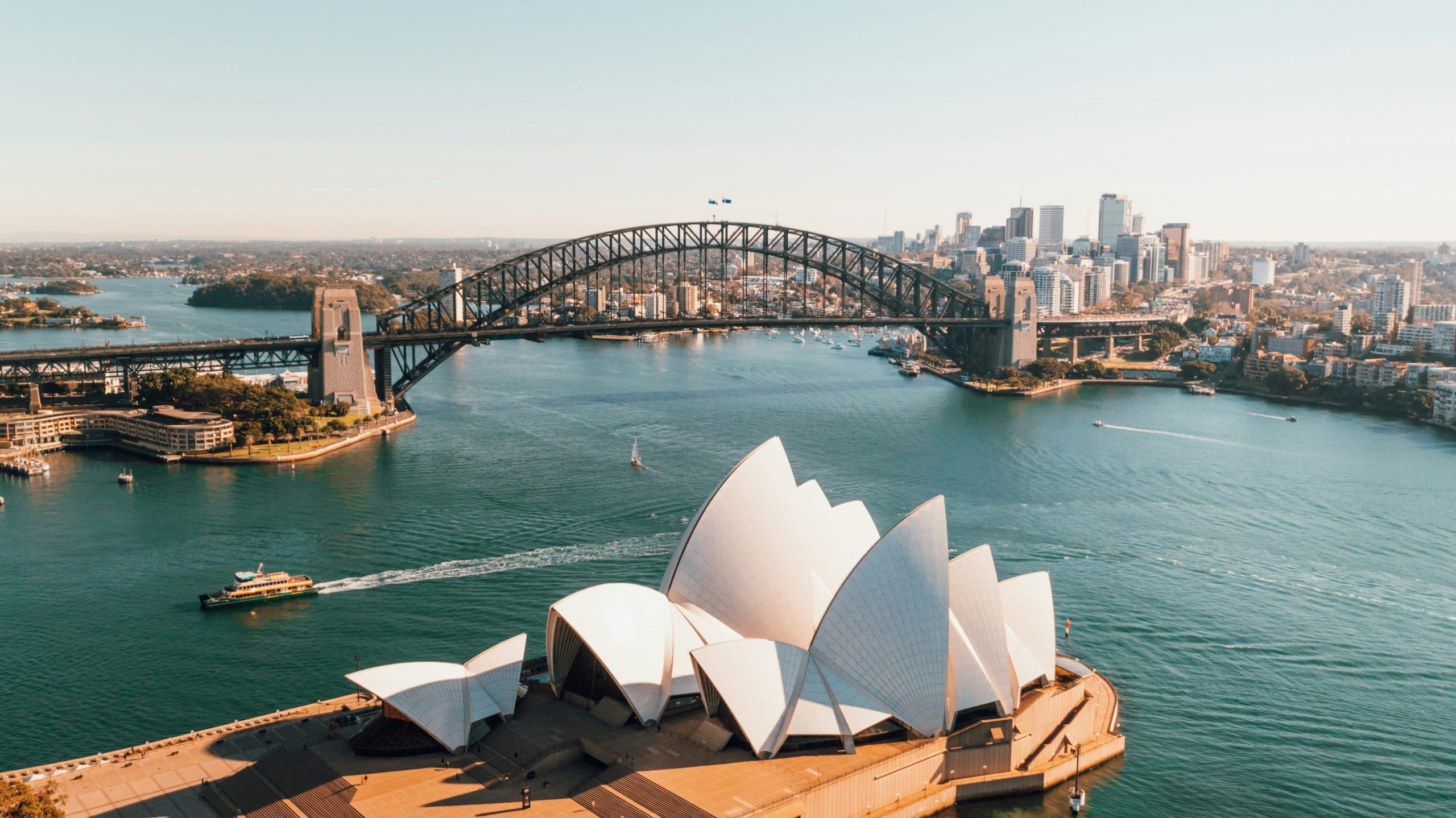 View of Sydney harbor with Habor Bridge and opera house. (Caleb/ Unsplash)