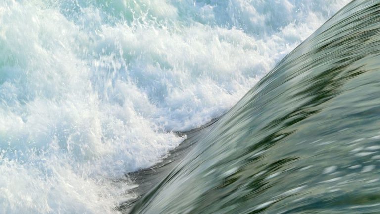 A sheet of water cascades to break into white foam