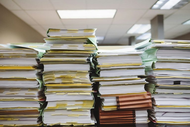 Stacks of paper files in an office (Wesley Tingey/Unsplash)