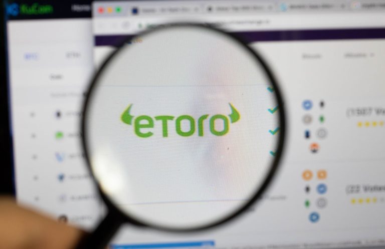 Magnifying glass over Etoro logo