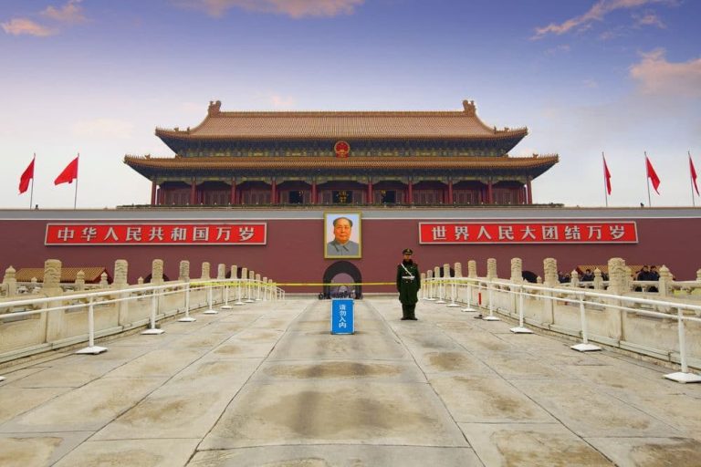 A lone guard stands in an empty square at the entrance to the Forbidden City, Beijing.