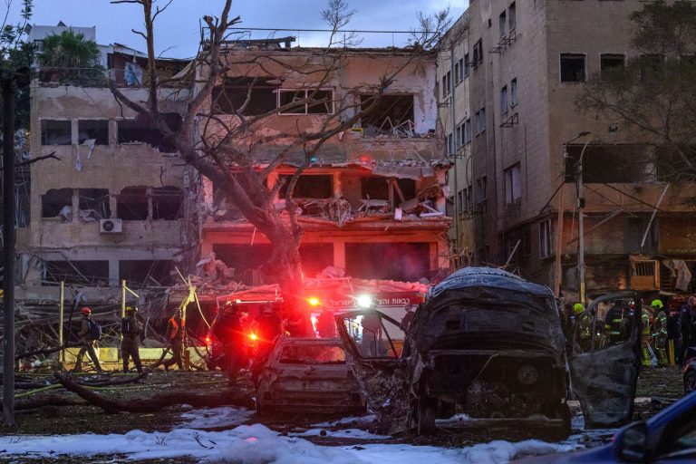 Israeli rescue workers and security personnel inspect and clear the buildings and area hit by an Iranian rocket on June 16, 2025 in Central Tel Aviv.