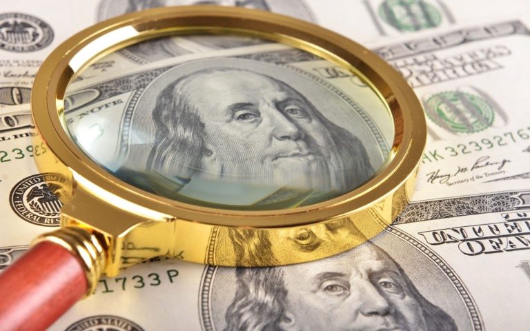 Dollars and magnifying glass