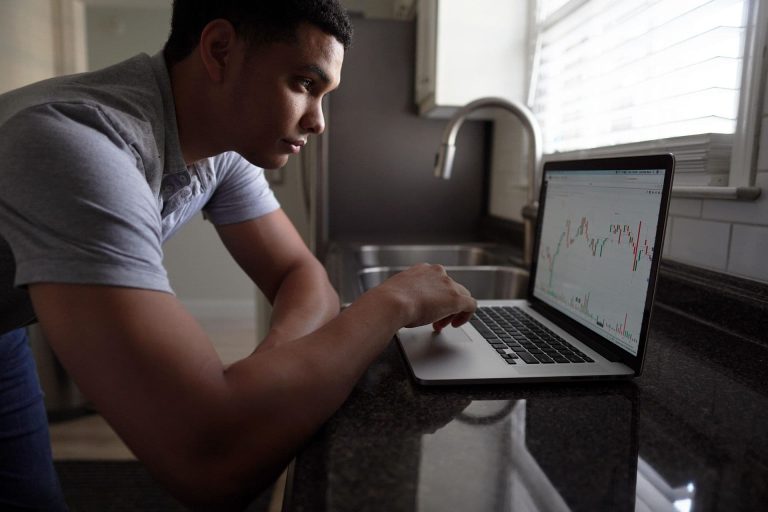 A man looks a chart on his laptop.