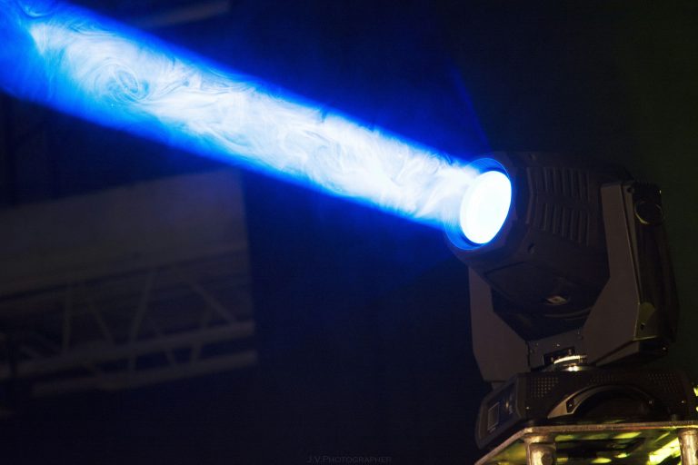 A single spotlight shines a blue-tinged beam against a dark background.
