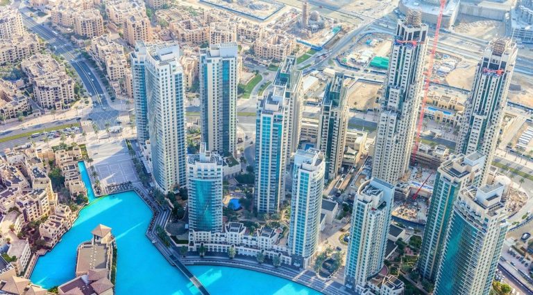 Aerial view of Dubai contrasting skycrapers with lower-rise buildings.