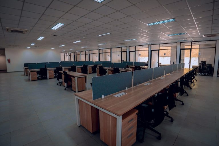 Empty office with lights on (Fiqih Alfarish/Unsplash)